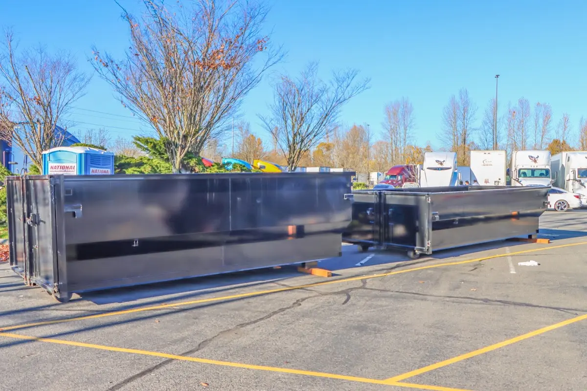 Professional dumpster rental service with roll-off container on residential driveway in Manistee